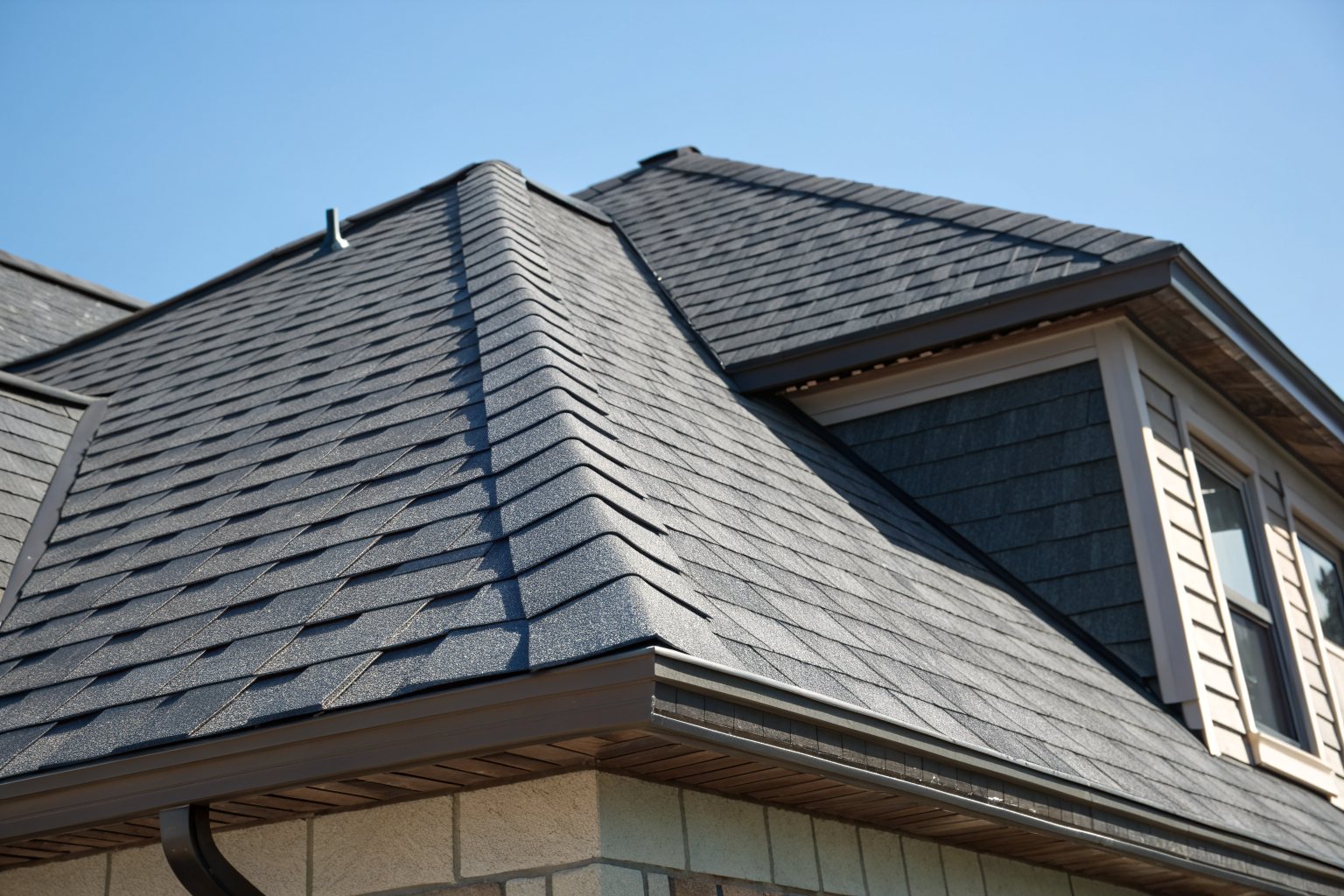 A ridge vent running along the peak of a new charcoal shingle roof